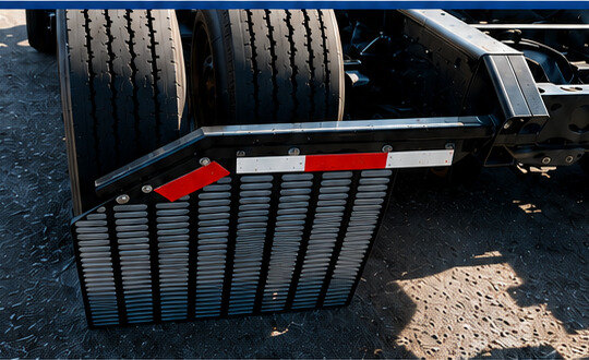 Streamline mud flap mounted behind the dual tires of a tractor-trailer